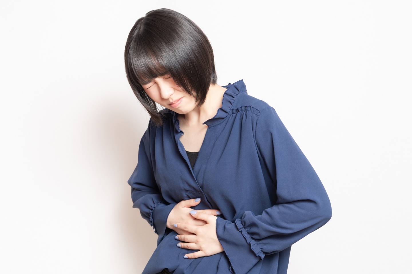 お腹を押さえる女性｜炎症性腸疾患（IBD）の薬物療法の副作用…鍼灸で緩和できます